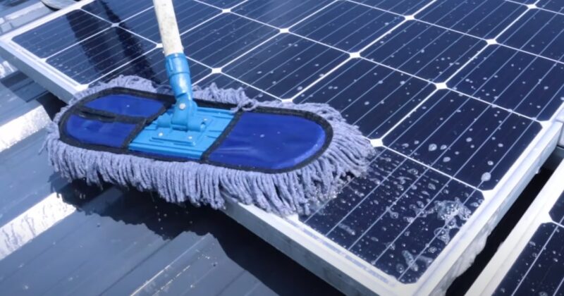 Using a brush to clean solar panels